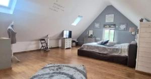 a bedroom with a bed in a attic at villa de luxe avec piscine et jacuzzi xxl in Dourlers +23 photos