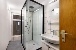 a bathroom with a glass shower and a sink at Ferienwohnung im Ländle in Reutlingen +18 photos