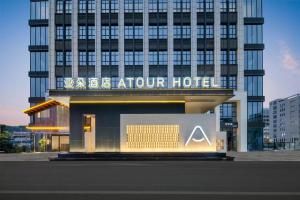 a hotel with a sign in front of a building at Atour Hotel Dongguan Huangjiang Xingguang Road in Dongguan