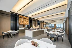 a restaurant with tables and chairs and a bar at Atour Hotel Dongguan Huangjiang Xingguang Road in Dongguan