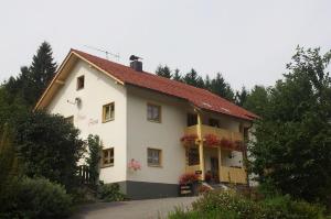 a white house with balconies and flowers on it at Haus Anna Königsdorfer in Neureichenau