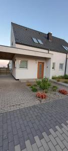 a house with a brick driveway in front of it at Garden Baltic in Trzęsacz