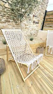 a white bench sitting on top of a wooden deck at La maison du Pays d'Auge in Troarn