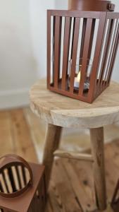 a wooden stool with a cage on top of it at La maison du Pays d'Auge in Troarn