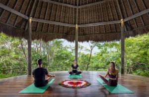 a group of people sitting in a circle in a yoga class at The Mesare Eco Resort in Nusa Penida