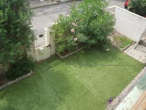 Una vista aérea de un patio con césped y flores. en Apprt'Nadia, en Aviñón