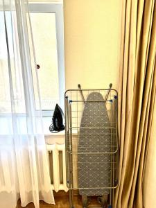 a shopping cart sitting in front of a window at Бухар -Жырау 72 in Karagandy +3 photos