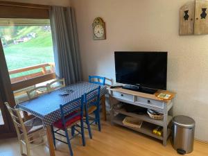 un salon avec une table et une télévision dans l'établissement Appartement Morzine, deux pièces, mezzanine, 4 personnes, à Morzine 8 autres photos
