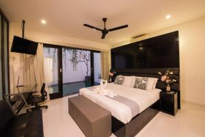 a bedroom with a large bed with a ceiling fan at 20 off Special Brilliant Location in Seminyak
