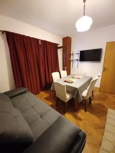 a living room with a table and chairs and a television at Apartmani Bada in Pakoštane