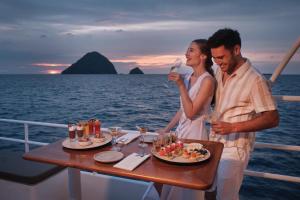 a man and a woman drinking wine on a boat at Perhentian Marriott Resort & Spa in Perhentian Islands