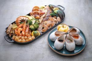 two trays of food with seafood on a table at Perhentian Marriott Resort & Spa in Perhentian Islands
