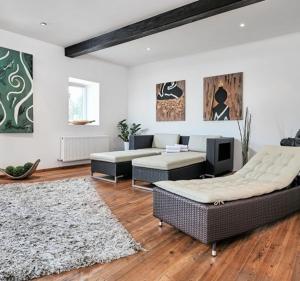 a living room with two couches and a rug at Hotel Bergglück in Filzmoos