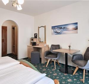 a hotel room with two beds and a table and chairs at Hotel Bergglück in Filzmoos