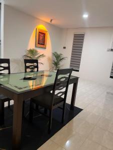 a dining room with a glass table and chairs at 23 Inn Singlebed Share Bathroom No Window in Bukit Mertajam +12 photos