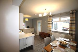 a kitchen and a dining room with a table and chairs at 3 Bed House - Sleeps 6 - Parking - Pets - Garden in Rowlands Gill +7 photos
