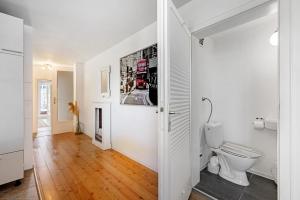 a bathroom with a toilet and a picture of a double decker bus at Balingen Apartment in Balingen +23 photos