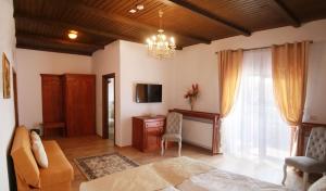 a bedroom with a bed and a desk and a television at Hanul Brancovenesc in Sîmbăta de Jos