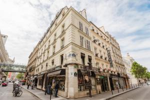 ein hohes weißes Gebäude auf einer Stadtstraße in der Unterkunft Hotel Prince Albert Opéra in Paris