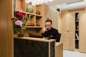 einem Mann, der an einem Schreibtisch mit einem Laptop sitzt in der Unterkunft Hotel Prince Albert Opéra in Paris