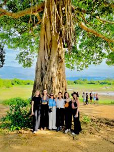 a group of people standing in front of a tree at Pearl White House in Udawalawe