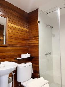 Un baño con inodoro, lavabo y ducha. en Riverhouse Resort, en Mae Sariang