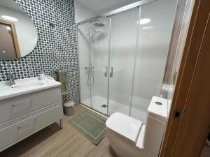 een badkamer met een douche, een toilet en een wastafel bij Apartamentos Torres del Milladoiro in Amés +25 foto's