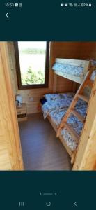 a small room with two bunk beds and a window at Domki Cichy Zakątek in Darłowo