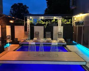 a swimming pool at night with tables and chairs at Hotel La Falaise Bonapriso in Douala