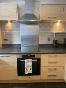 a kitchen with a stove with a towel on the oven at 4 Bed House - Sleeps 8 - Wifi - Parking in West Thurrock