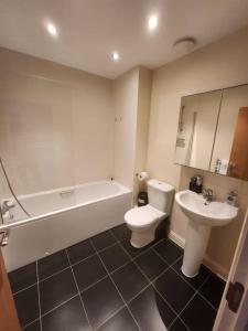 a bathroom with a sink and a toilet and a bath tub at 4 Bed House - Sleeps 8 - Wifi - Parking in West Thurrock
