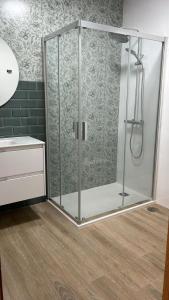 een douche met een glazen omhulsel in een badkamer bij Apartamentos Torres del Milladoiro in Amés