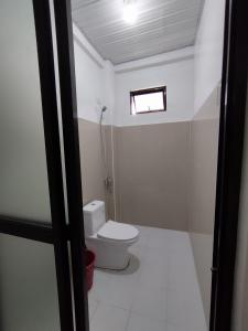 a small bathroom with a toilet and a window at RedDoorz at Elton Guesthouse in Numancia