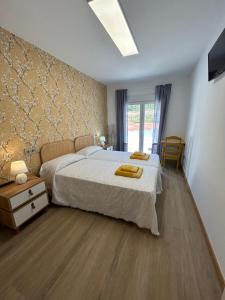 een slaapkamer met een groot wit bed en een raam bij Apartamentos Torres del Milladoiro in Amés