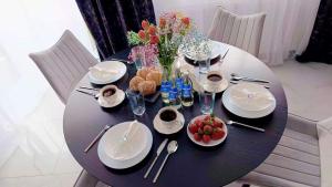 a black table with white plates and flowers on it at Apartamenty Chęciny in Chęciny +8 photos