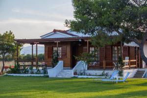 a house with two chairs in a yard at ThemiLia Beachfront, Luxury House in Néa Ankhíalos