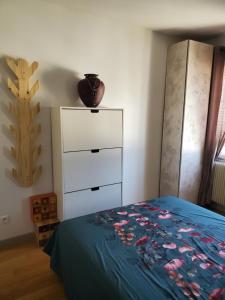 ein Schlafzimmer mit einem Bett und einer Kommode in der Unterkunft Colibri in Rocquencourt