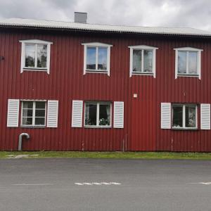 a red building with white windows and a street at Åkersjön lägenhet in Vallrun