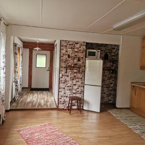 a kitchen with a refrigerator and a chair in a room at Åkersjön lägenhet in Vallrun