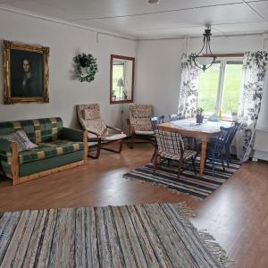a living room with a table and a couch at Åkersjön lägenhet in Vallrun