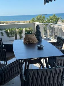 a blue table with a statue sitting on a patio at Sea View Residence by MD in Alexandroupoli