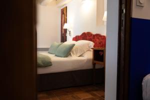a bedroom with a bed with pillows and a mirror at Oustau Camarguen Hôtel & Spa in Le Grau-du-Roi