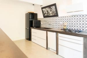 a kitchen with a black refrigerator and white cabinets at CASA MIRA in Orosei