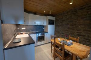 a kitchen with a wooden table and a kitchen with a sink at Tis Ouranias in Koukkoúlion
