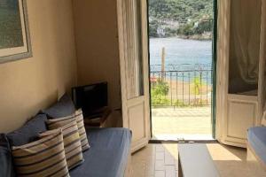 a living room with a blue couch and a sliding glass door at Kioni Apartments in Vathi, Ithaka +1 photo