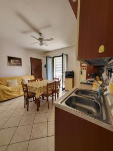 a kitchen with a sink and a table with chairs at Casa Angela in Valledoria