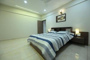 a bedroom with a large bed with blue and white sheets at The Grace Residence - Unmarried Couples Not Allowed in Manipala