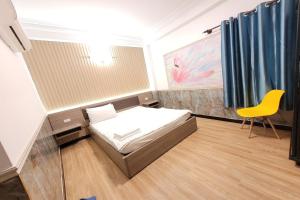 a small bedroom with a bed and a yellow chair at Hoang Nam Hotel in Ho Chi Minh City