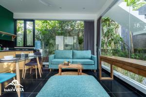 ein Wohnzimmer mit einem blauen Sofa und einem Tisch in der Unterkunft Casa Kirala by Bukit Vista in Uluwatu