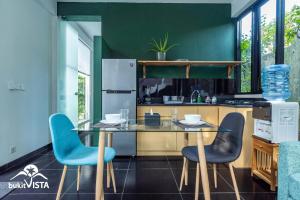 eine Küche mit einem Glastisch und blauen Stühlen in der Unterkunft Casa Kirala by Bukit Vista in Uluwatu